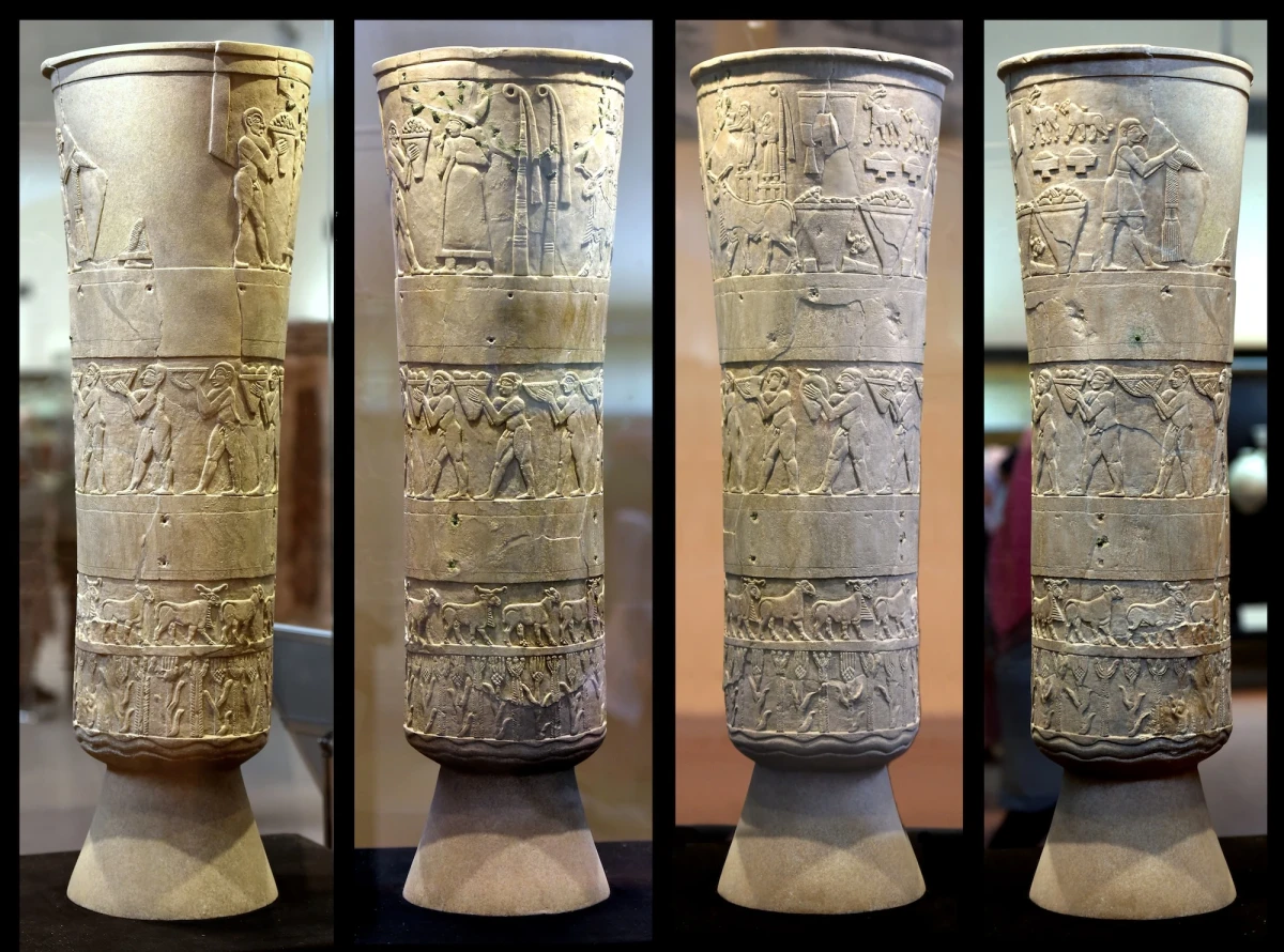 The Warka Vase or Uruk Vase, glowing a rich amber under museum lights, in a series of four close-up views of its sides.