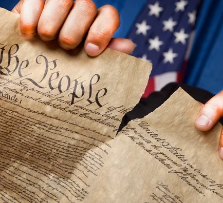 Hands ripping the original Constitution in half