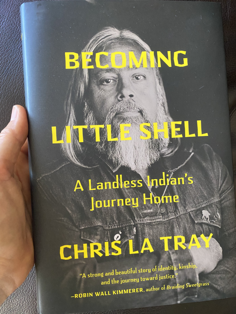 A hand holds Chris La Tray's new book, Becoming Little Shell