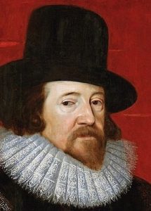 Headshot portrait of Francis Bacon with black stiff-brimmed hat and frilly white lace collar and dark beady eyes